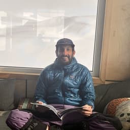Rajiv reading a magazine in a mountain hut